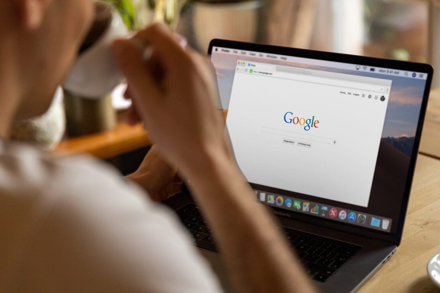 Osoba korzysta z wyszukiwarki Google na laptopie